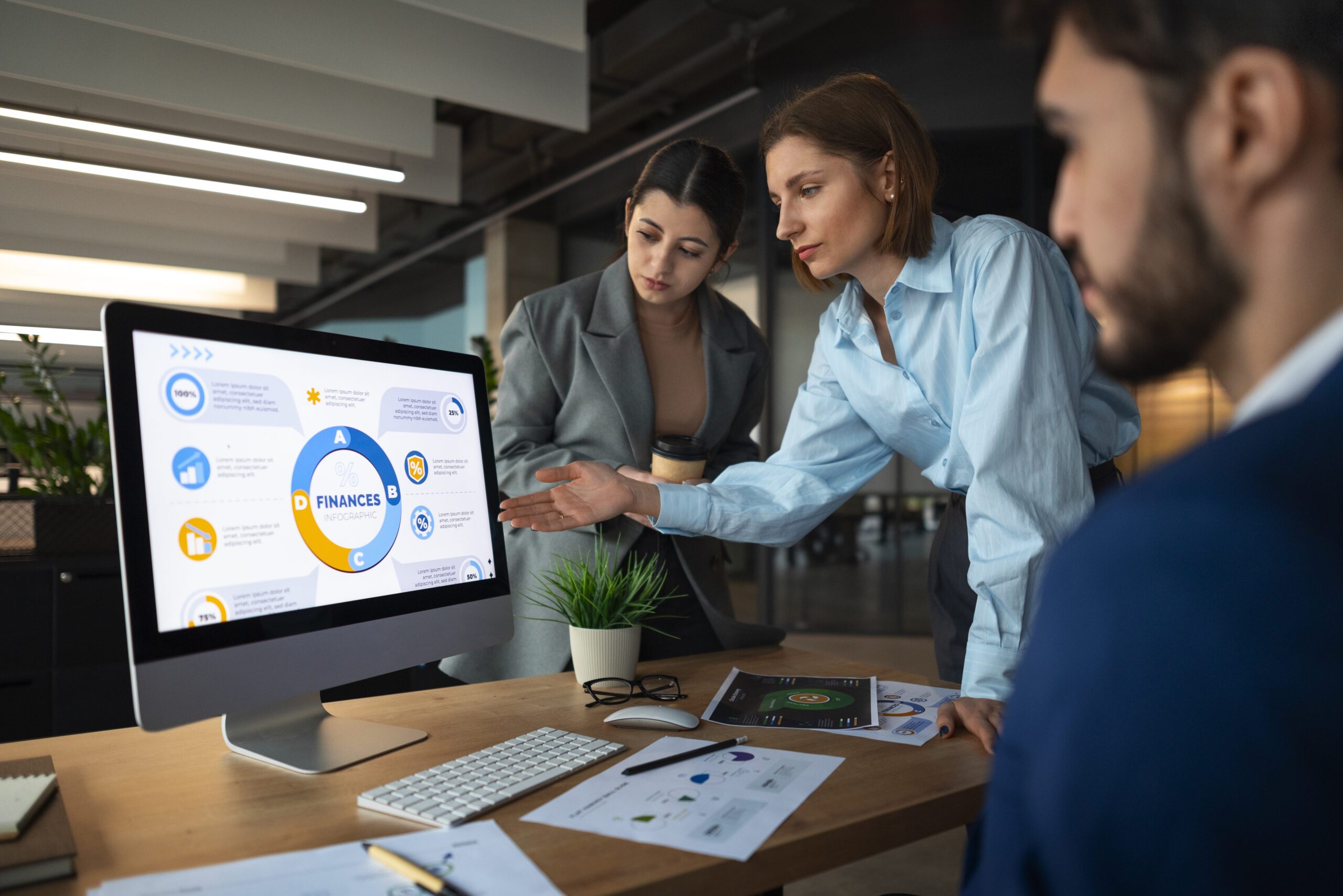 Professional financial partner reviewing client reports in a modern office while team members collaborate in the background.